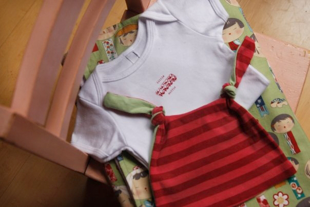 Chair with onesie and baby hat